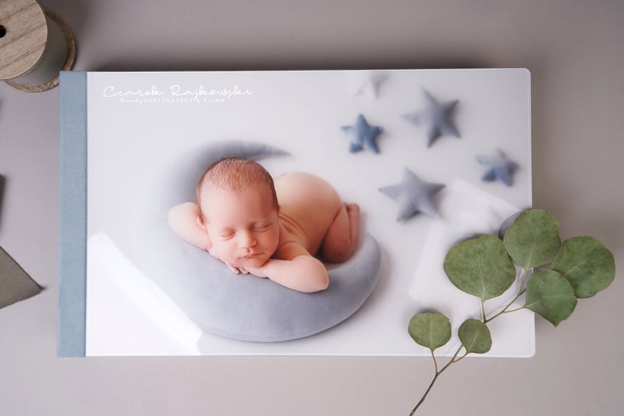 Newborn baby on the cover of a Folio Box with an acrylic cover