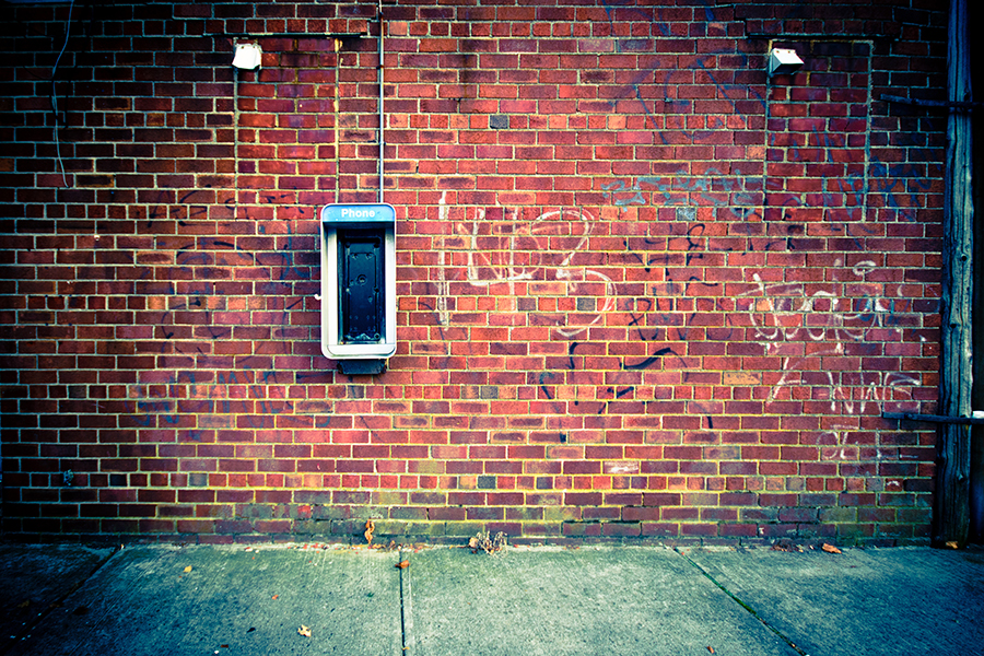 old phone at brick wall